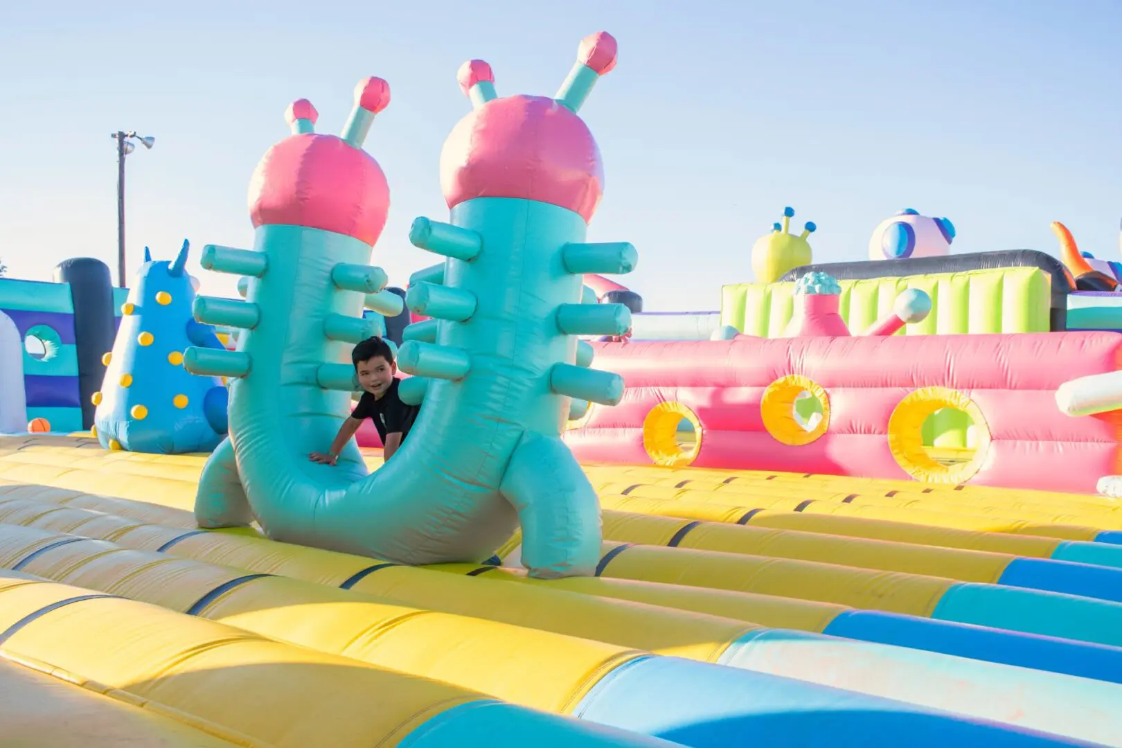 A boy is playing on an inflatable slide.