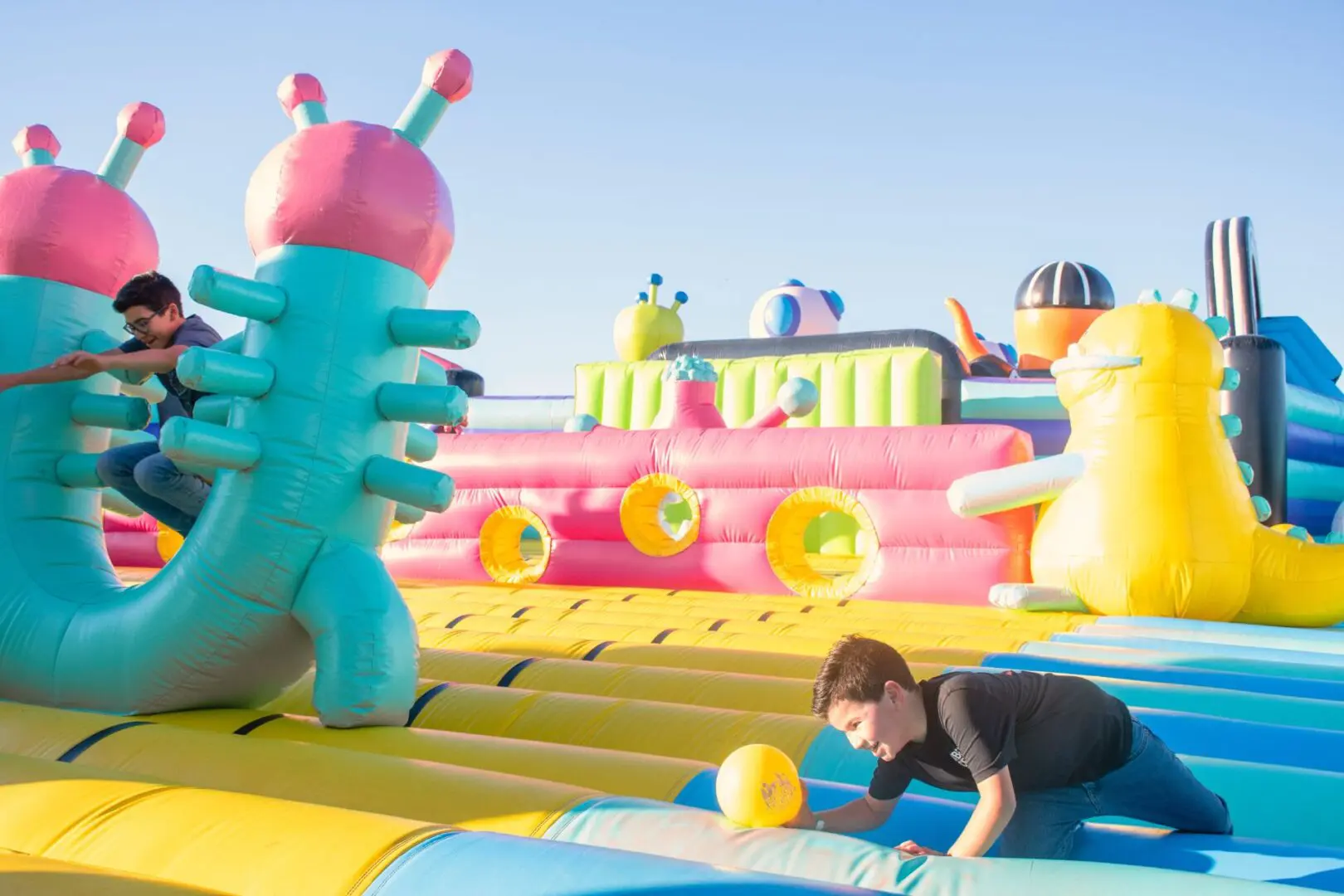 A person on an inflatable slide in the sun.
