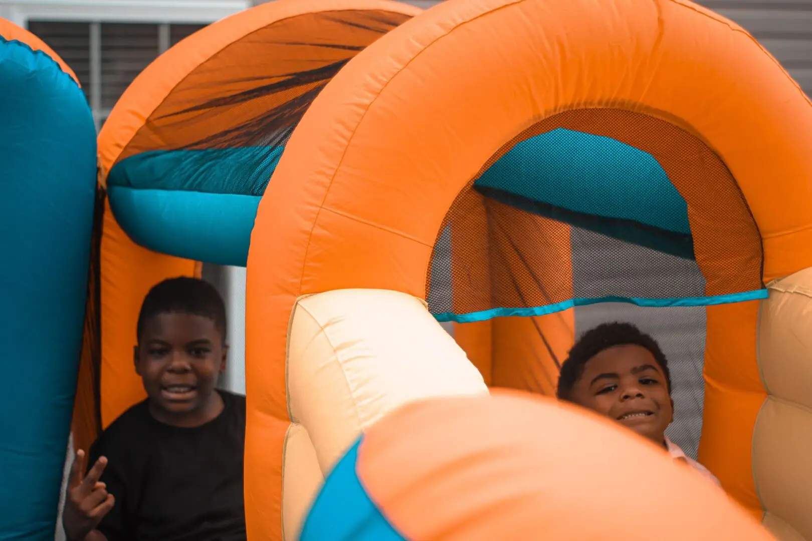 Two boys are playing in an inflatable playground.